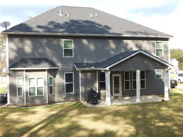 a view of a house with large windows and yard