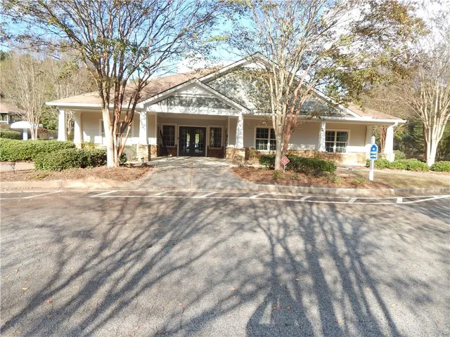 a front view of a house with a yard and fountain