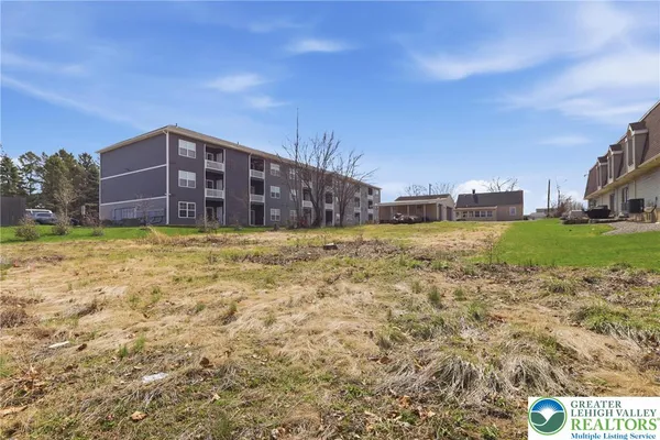 a view of a big yard with a building in the background