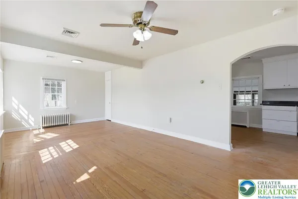 a view of a kitchen with a stove cabinets wooden floor and a ceiling fan