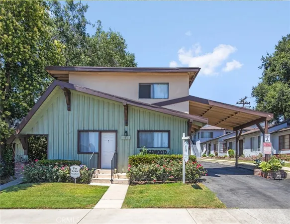 a front view of a house with a garden and plants