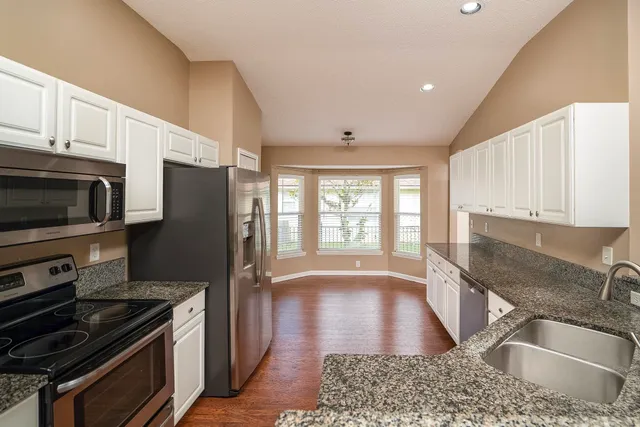 a kitchen with granite countertop a refrigerator and a sink