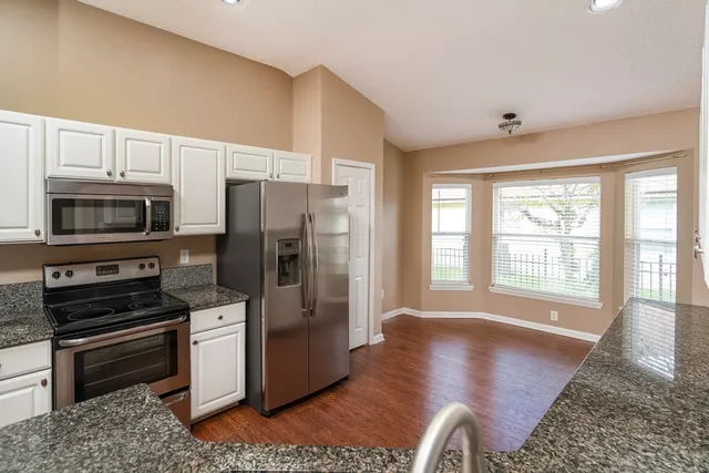 a kitchen with stainless steel appliances granite countertop a refrigerator stove and microwave