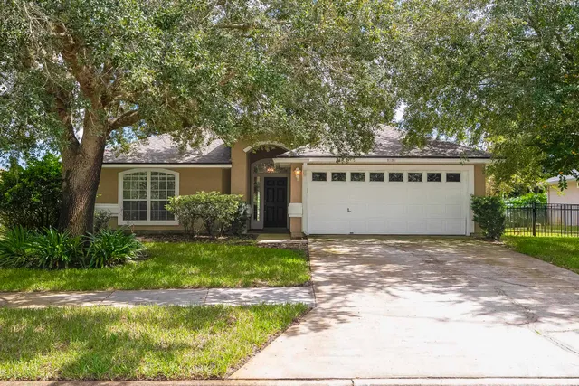 a front view of a house with a yard garage and outdoor seating