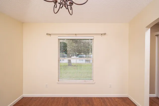 a view of a room that has a window and a wooden floor
