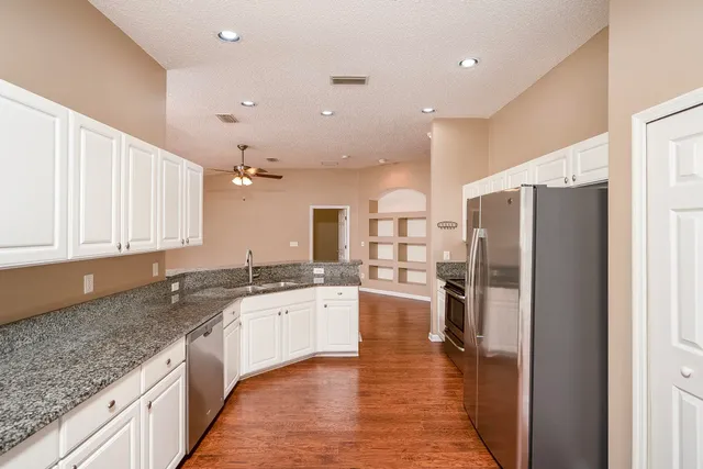 a kitchen with stainless steel appliances granite countertop a refrigerator and a sink