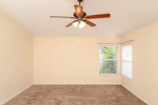 a view of a room with a window and a ceiling fan
