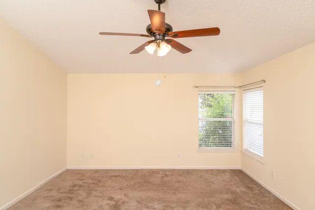 a view of a room with a window and a ceiling fan