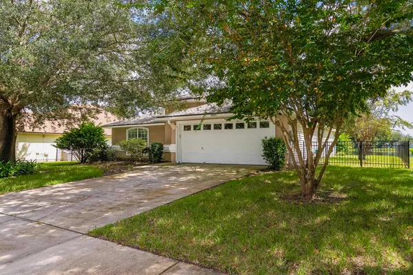 a view of a house with backyard and a tree