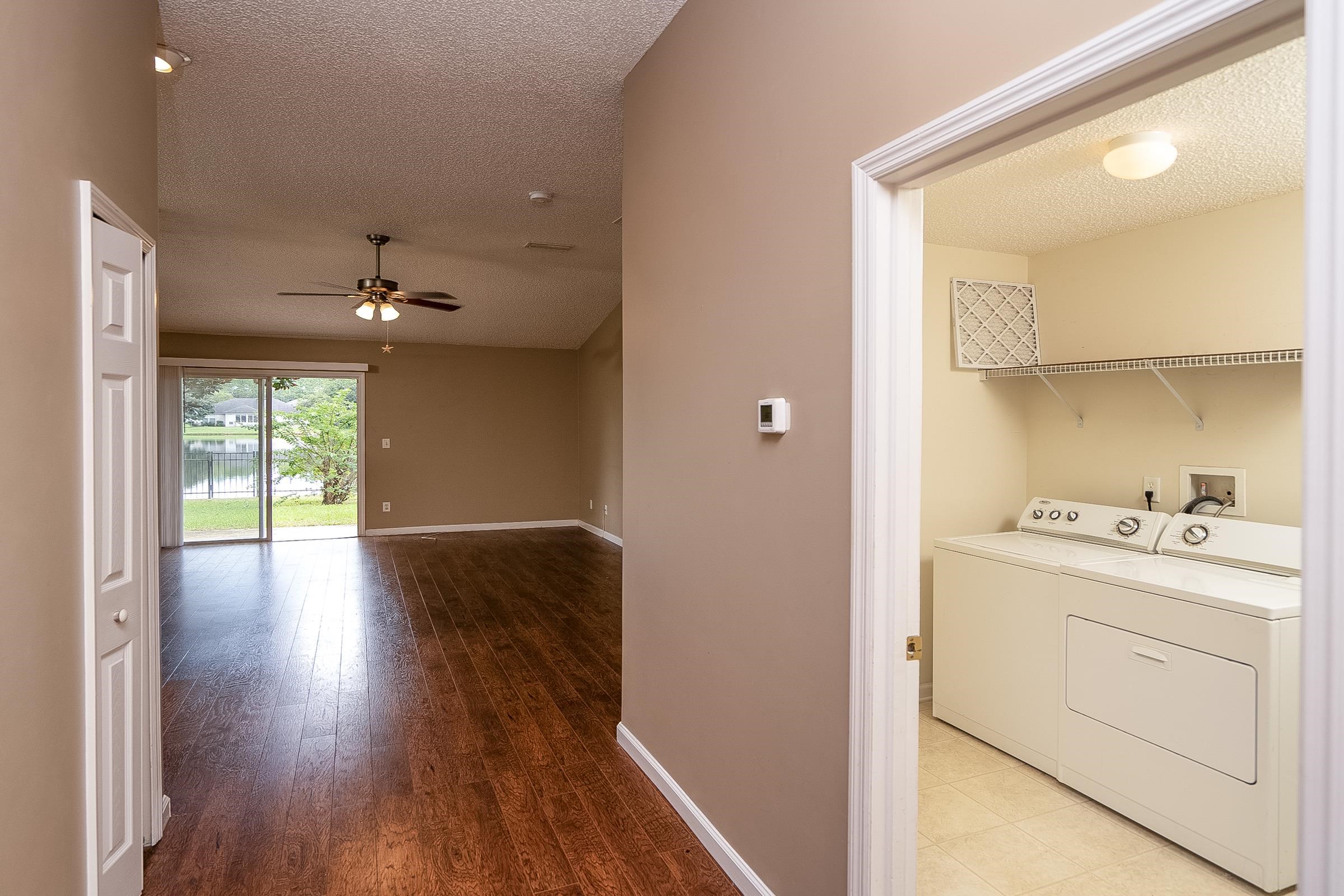 1732 South Summer Ridge Court St. Augustine, FL 32092 - Photo 34 of 42 a hallway with wooden floor cabinets and a kitchen