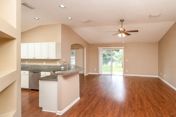 a kitchen with stainless steel appliances granite countertop a stove cabinets and wooden floor