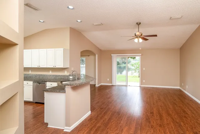 a kitchen with stainless steel appliances granite countertop a stove cabinets and wooden floor