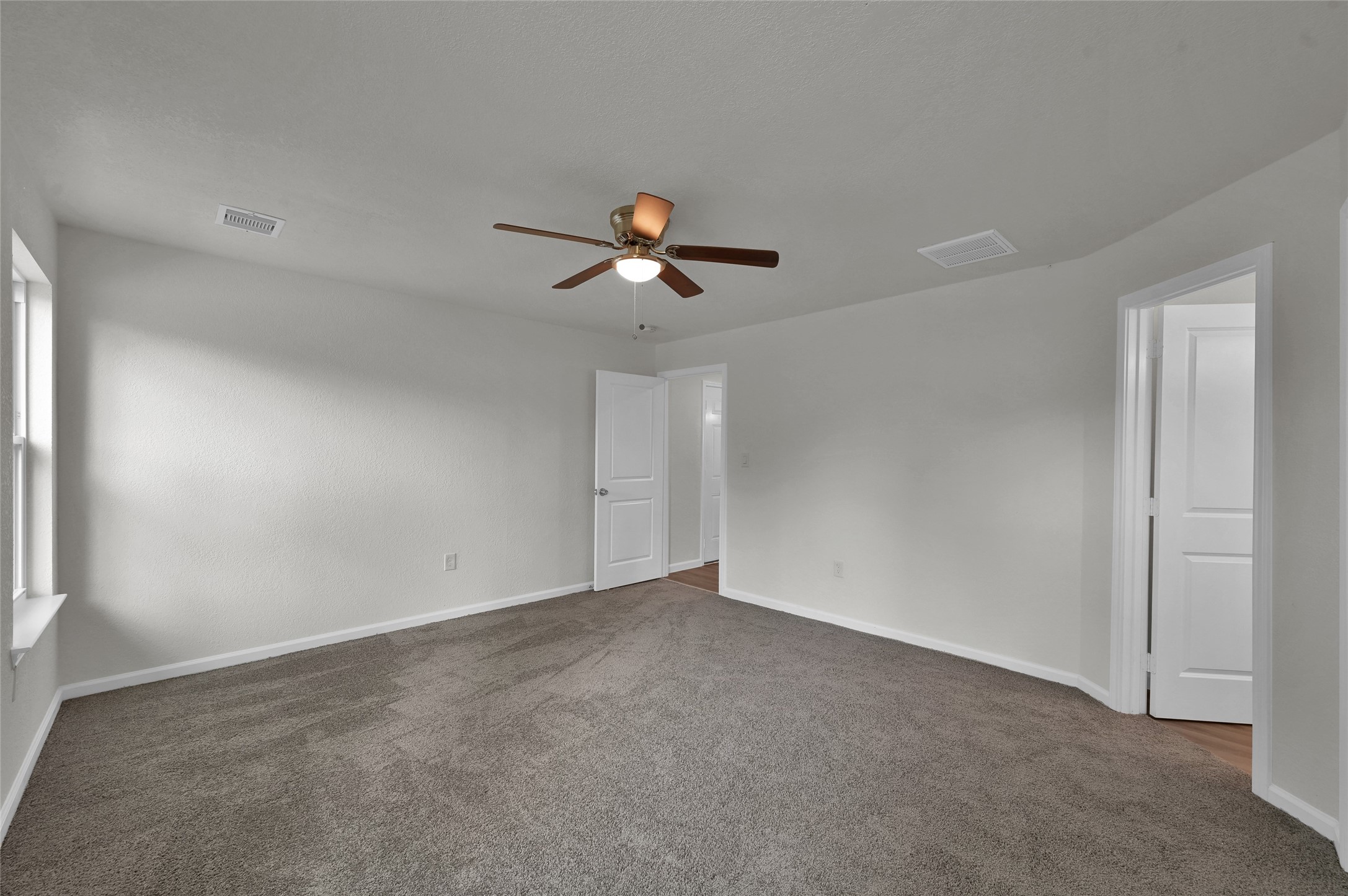 2826 Hopper Road Houston, TX 77093 - Photo 13 of 24 an empty room with ceiling fan and window