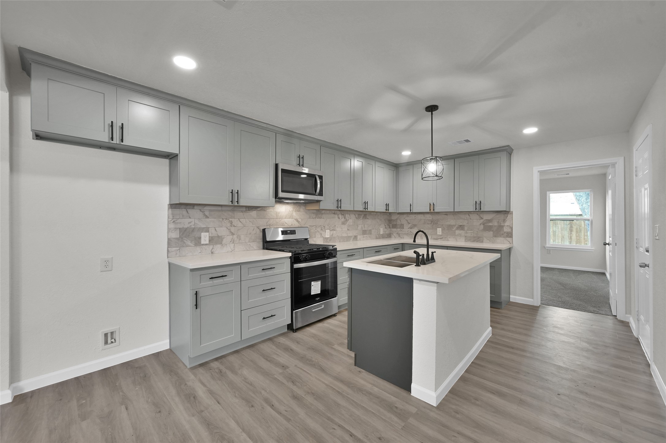 2826 Hopper Road Houston, TX 77093 - Photo 9 of 24 a white kitchen with a sink and dishwasher a refrigerator with wooden floor