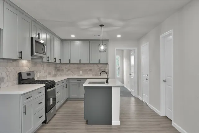 a kitchen with stainless steel appliances granite countertop a sink stove and refrigerator