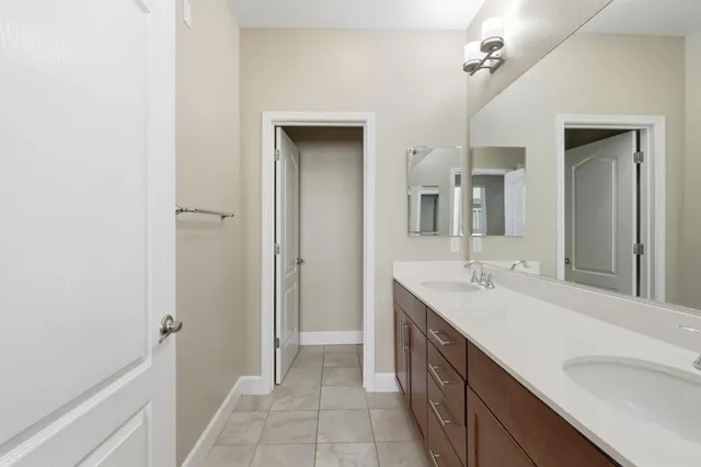 a bathroom with a double vanity sink a mirror and a shower