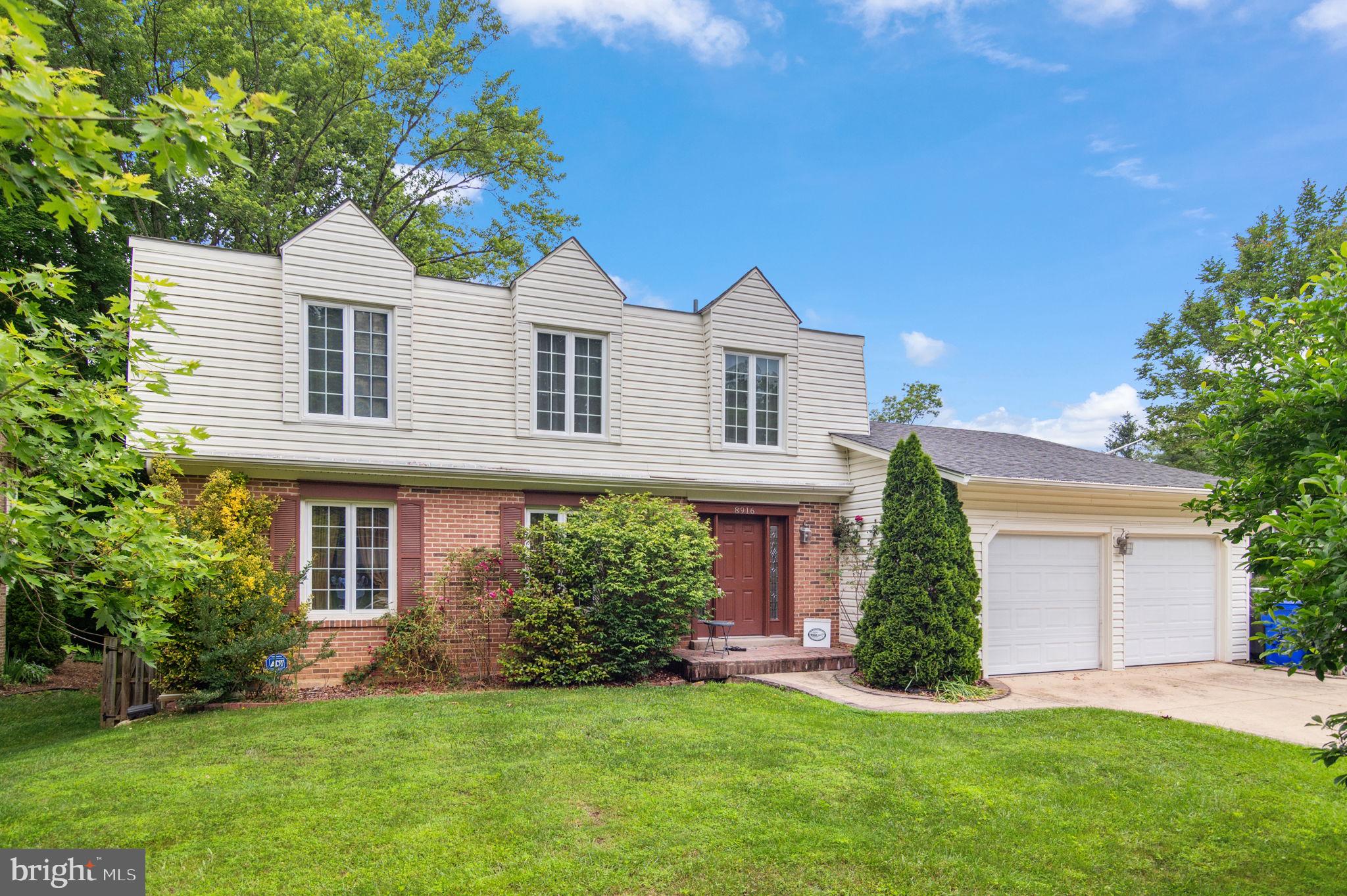 a front view of a house with a garden and yard