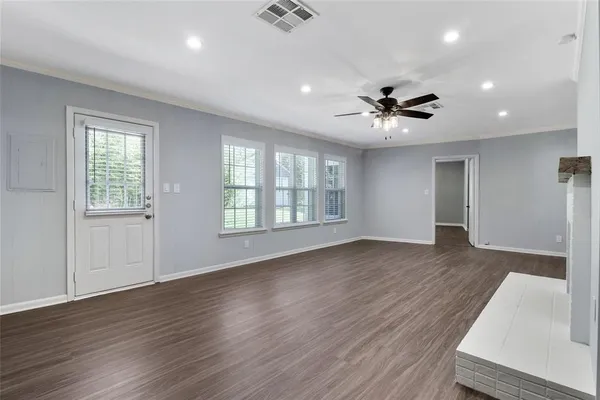 a view of an empty room with window and wooden floor