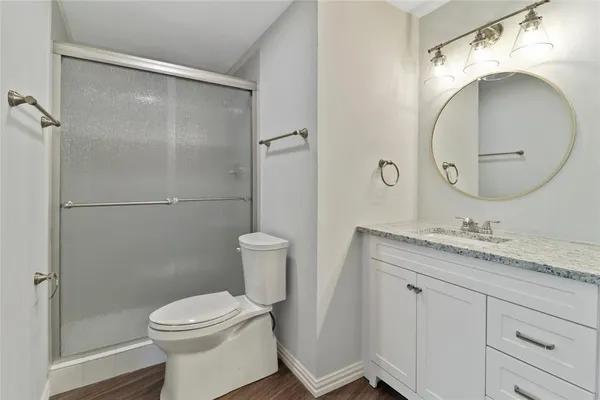 a bathroom with a granite countertop toilet sink and a mirror