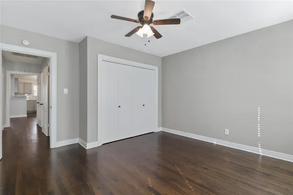 a view of a room with wooden floor and a ceiling fan