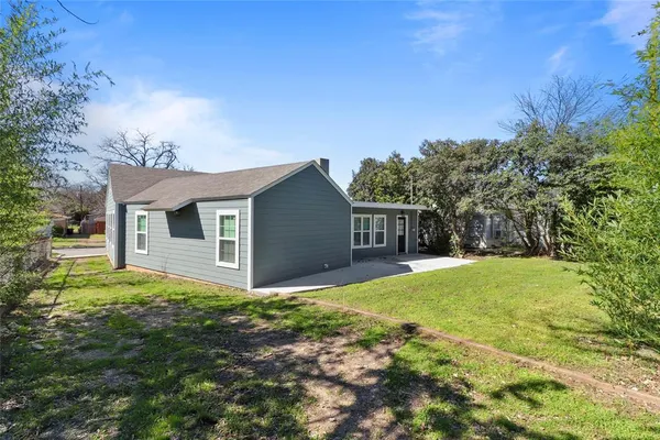 a front view of a house with yard and tree
