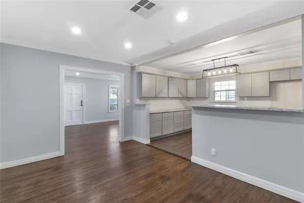 a view of a kitchen with a sink and dishwasher white cabinets with wooden floor