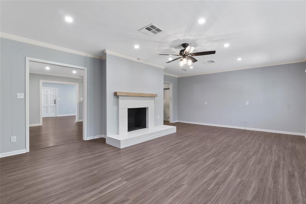 3557 Winston Road Fort Worth, TX 76109 - Photo 10 of 25 a view of an empty room with wooden floor and a fireplace
