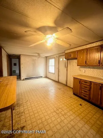 a view of a livingroom with wooden floor and kitchen
