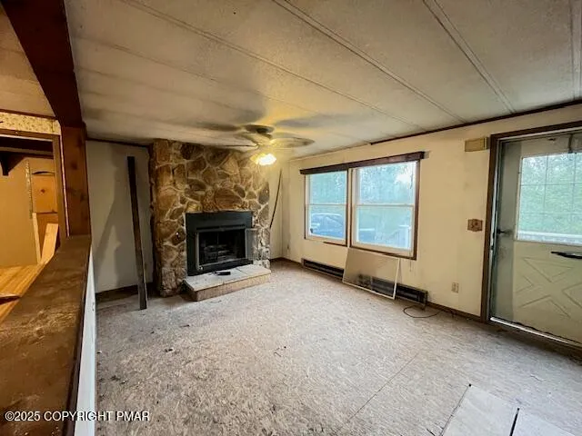 a view of an empty room with window and fire place