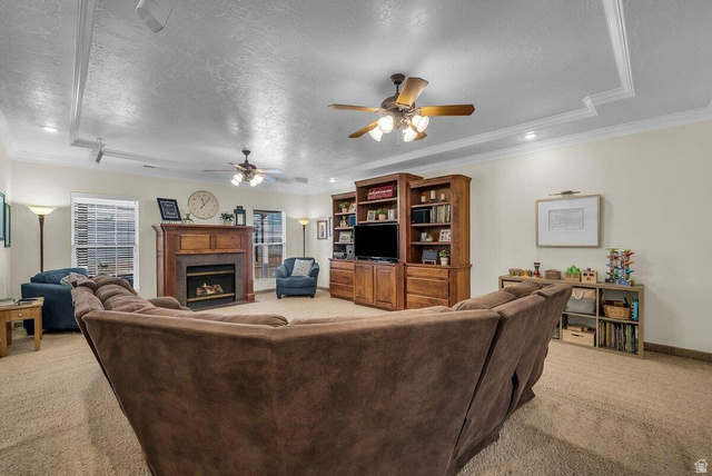 841 1010 S Street St. George, UT 84790 - Photo 7 of 33 Living room featuring crown molding, light carpet, a fireplace, recessed lighting, and a ceiling fan