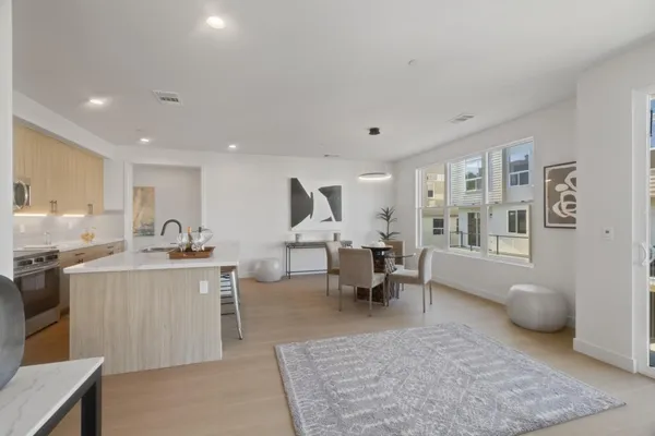 a large living room with stainless steel appliances granite countertop a couch and cabinets