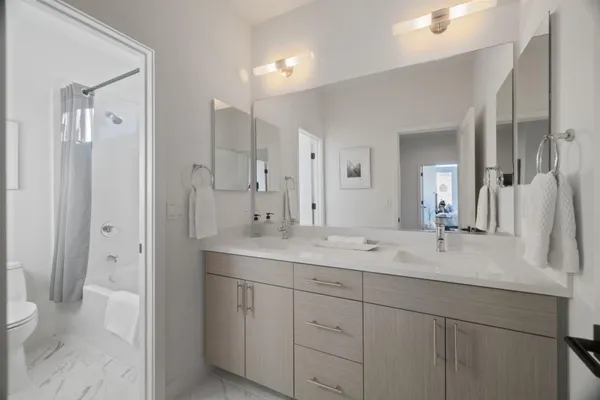 a bathroom with a double vanity sink mirror and toilet
