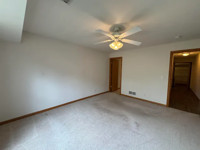 an empty room with a window and a ceiling fan