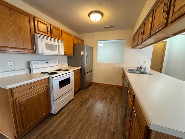 a kitchen with stainless steel appliances a stove a sink and a refrigerator