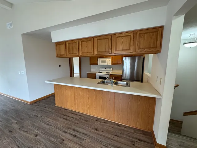 a kitchen with stainless steel appliances granite countertop a sink refrigerator and cabinets