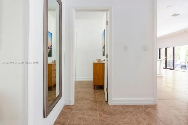 a view of a hallway with wooden floor and closet