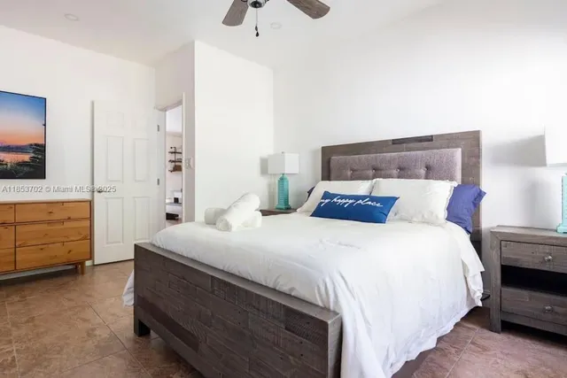 a bedroom with a bed and a flat tv screen on dresser