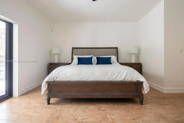 a bed sitting in a bedroom next to a window