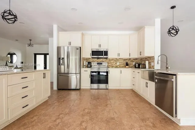 a kitchen with white cabinets and stainless steel appliances