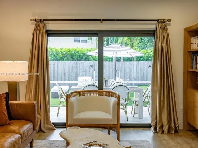 a dining room with furniture a flat screen tv and a floor to ceiling window
