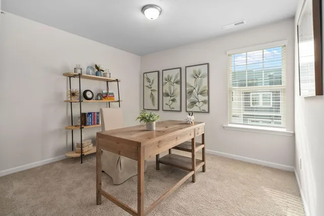 a view of a workspace with furniture and a window