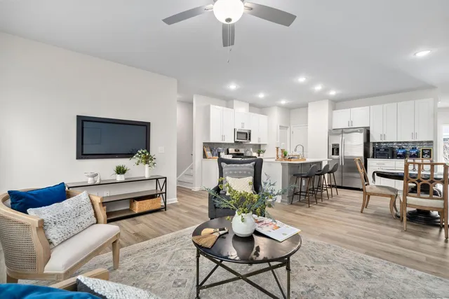 a living room with furniture kitchen view and a flat screen tv