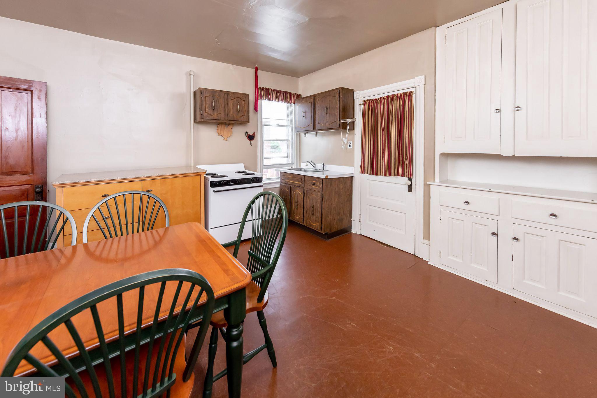 504 West Broad Street Gibbstown, NJ 08027 - Photo 9 of 37 a kitchen with stainless steel appliances granite countertop a stove a refrigerator a dining table and chairs with wooden floor