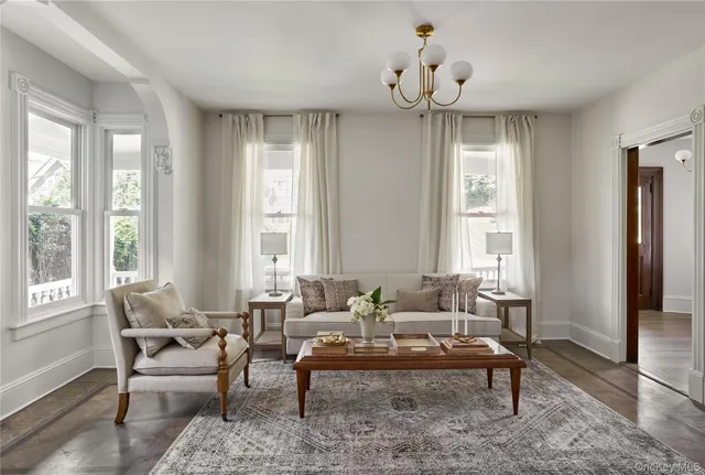 a living room with furniture wooden floor and a window