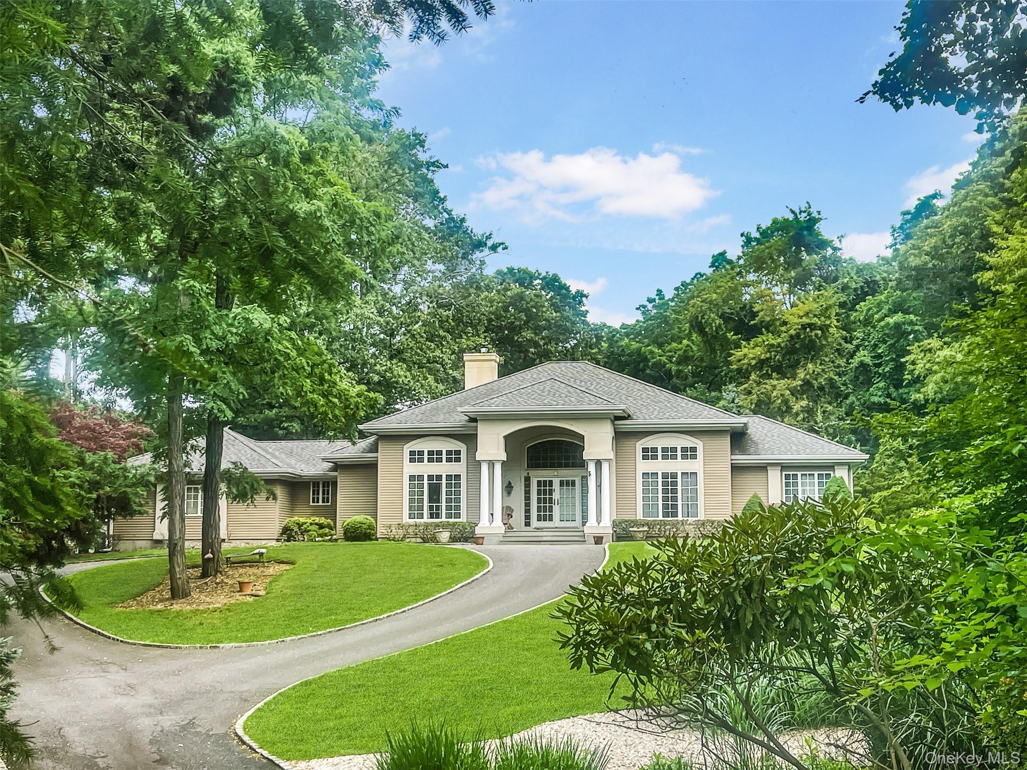 View of front facade with a front lawn, a chimney, roof with shingles, and french doors