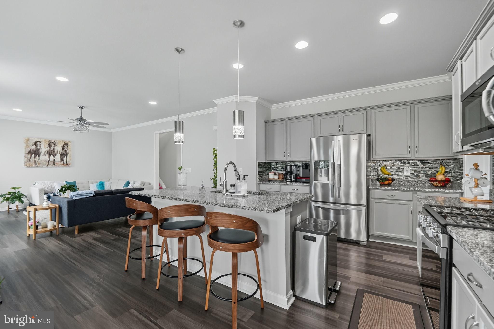 119 Interlace Way Stephenson, VA 22656 - Photo 3 of 22 a kitchen with stainless steel appliances granite countertop a refrigerator a stove a sink a dining table and chairs with wooden floor