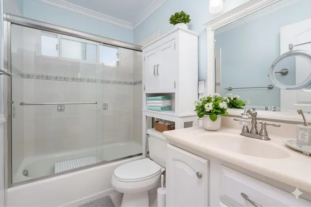a bathroom with a granite countertop sink a toilet and shower