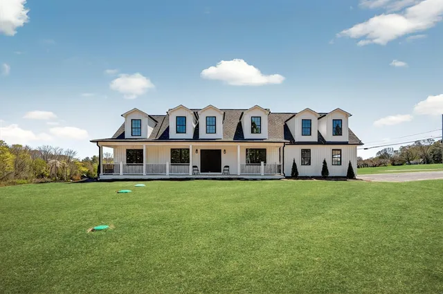 a view of a house with a big yard and large trees