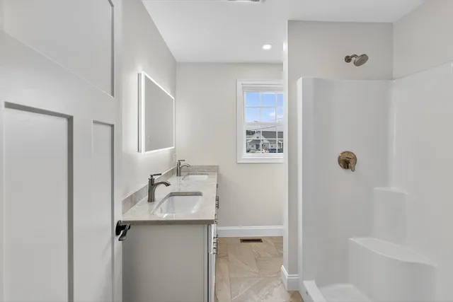 a bathroom with a sink a toilet and shower