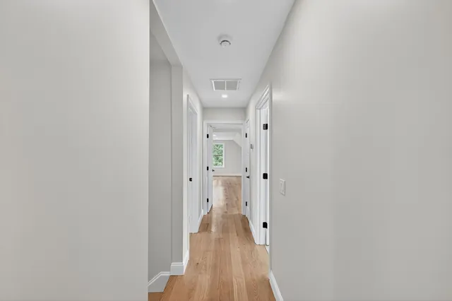 a view of a hallway with wooden floor